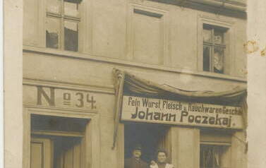 Ewolucja szyld&oacute;w - szyld w języku niemieckim Johann Poczekaj 
